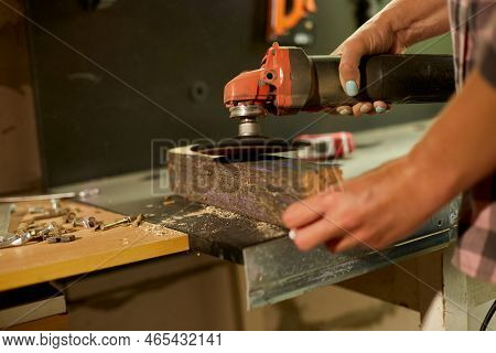 Close Up Of A Worker Woman Hand Grinds, Sanding The Wood In Workshop