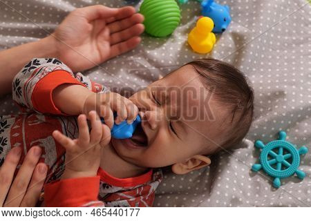 Cute Adorable Newborn Baby Playing With Colorful Rattle Toy. Baby With Teether. Six Months Old Lovel