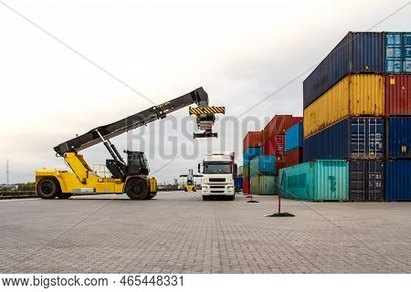 Truck While Loading In Logistic Shipping Yard With Cargo Container. Forklift Truck Handling Truck. L