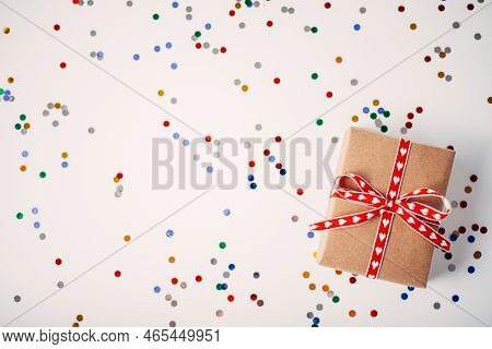 Gift Or Gift Box And Confetti On The White Table On Top. Flat Arrangement For Birthday, Mothers Day 
