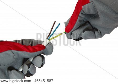 An Electrician Removes Insulation From A Three-core Copper Wire. Hands In Protective Gloves And Elec