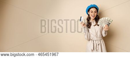 Microcredit And Money Concept. Young Stylish Woman Showing Credit Card And Dollars Cash, Smiling Hap