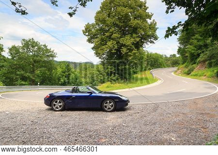 Hunsrueck, Germany - June 26, 2021: Blue Roadster Porsche Boxster 986 At Street With Hairpin Turn In