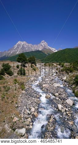 Stream Flowing Down From The Distant Mountains In Close-up. Beautiful Landscape With A Mountain, Riv