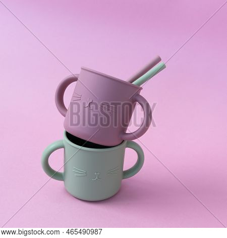 Modern Pastel Color Silicone Sippy Cups With Straws On Pink Background. Baby Tableware, First Feedin