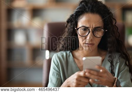 Closeup Photo Of Anxious Woman Looking At Cell Phone Screen