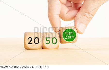 2050 Year Net Zero Carbon Neutral Concept. Hand Picking A Net Zero Symbol Wooden Blocks With Text. C