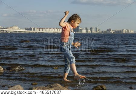 Happy Girl Of 4 Years On Summer Beach Summer Wetes Legs In Sea, Selective Focus