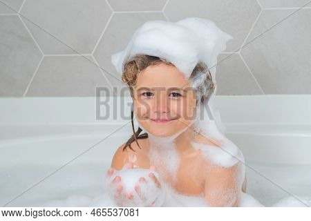 Children Bathing. Child With Shampoo Foam And Bubbles On Hair Taking Bath. Funny Face Of Kid In Foam