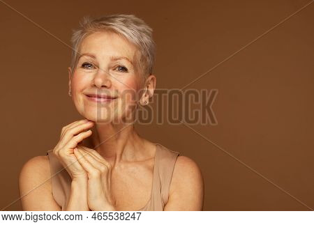 Beauty Portrait Of Mature Woman Smiling With Hand On Face.