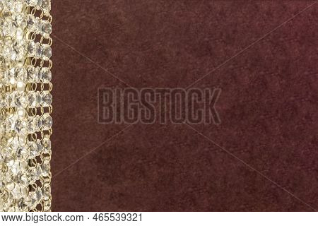 Part Of A Crystal Chandelier On A Burgundy Background. Selective Focus. Space For Text.