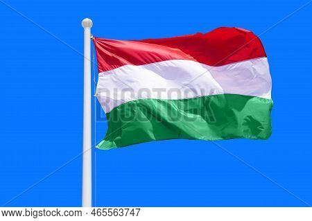 Hungary Flag Waving Against Clean Blue Sky, Close Up. Hungary Flag In The Blue Sky. Flag Hungary On 
