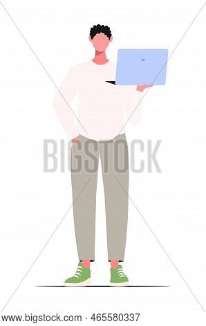 A Young Modern Attractive  Guy In Casual Clothes Holding In Hands Laptop Working  And Play Online. I