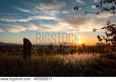 Autumnal Sunset Landscape In Sleza Massif, Poland. Old Dried Tree Trunk In Foreground.