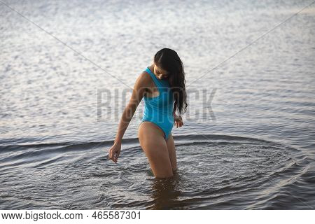 Young And Beautiful Woman Looking Into The Water Of The Caribbean Sea In Mexico.
