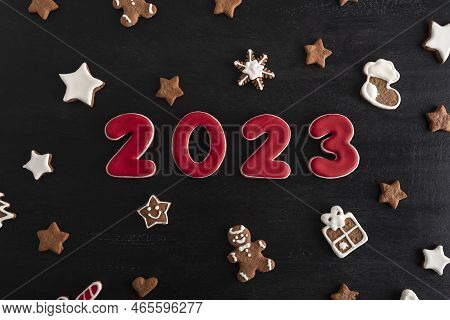 Inscription 2023 From Gingerbread Cookie. Christmas Bacing, Black Background.