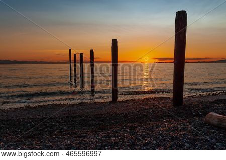 Silhouettes Of  Remnants Of An Early 1900's Pier  At Sunset In Point Roberts, Washington State, Usa