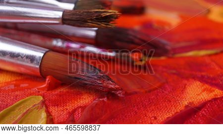 Many Brushes On Artist's Palette With Mixed Paints, Closeup