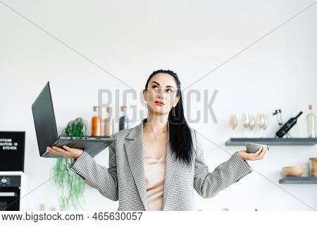 The Girl Thinks She Should Take A Vacation Or Go To Work. Young Business Lady Holding A Laptop For W