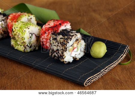 Velsmagende Maki sushi - Roll på måtten på brune baggrund