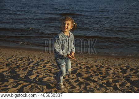 Girl Of 4 Years On Summer Beach Summer Running On Sand In Denim Suit, Selective Focus