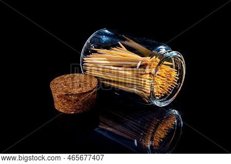 Bamboo Wooden Toothpicks In Glass Jar, Wine Glass. In Bucket. Toothpicks On Black Background. Front