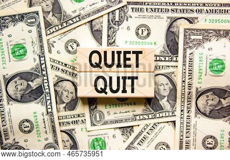 Quiet Quit Symbol. Concept Words Quiet Quit On Wooden Blocks. Beautiful Background From Dollar Bills