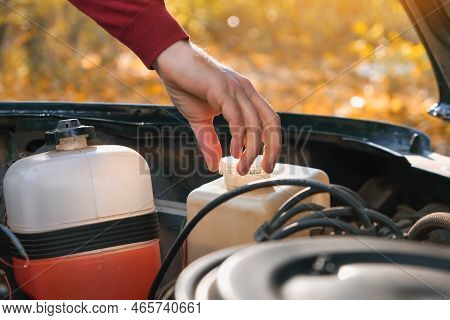 A Man Checks The Level Of Technical Fluids Of The Car. Self-service Of The Car. Periodic Check Of Th