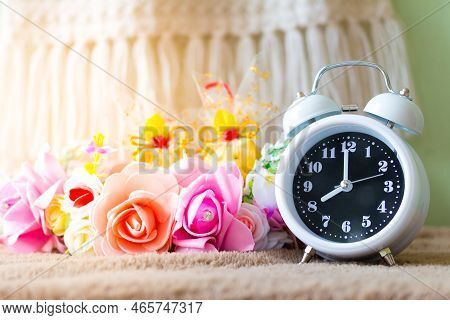 White Clock With Flowers On A Table In Muted Vintage Retro Style.