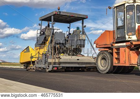 Asphalt Laying Equipment. Work On The Device Of A New Road Surface In A Modern City. Powerful Constr