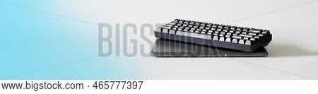 Small Laptop And A Trendy Black Mechanical Computer Keyboard For Esports On A White And Blue Gradien