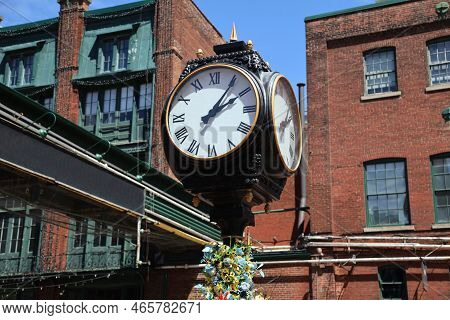 The Clock In The Historic Distillery District In Toronto, Canada. High Quality Photo