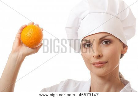 Smilende kvinde cook med orange, isoladed på hvid baggrund