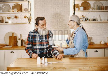 Senior Woman And Man At Home Meassure Blood Pressure