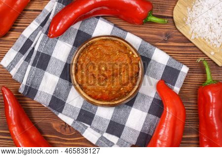 Ajvar From Paprika, Tomatoes, Garlic And Onions With On A Brown Wooden Table. Balkan Food. Selective