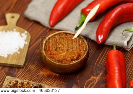 Ajvar From Paprika, Tomatoes, Garlic And Onions With On A Brown Wooden Table. Balkan Food. Selective