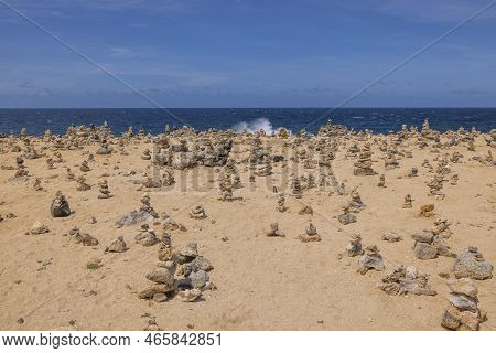 Close Up View Of Atlantic Ocean Coastline Decorated With Cute Small Pyramids Made Of Stones. Dark Bl