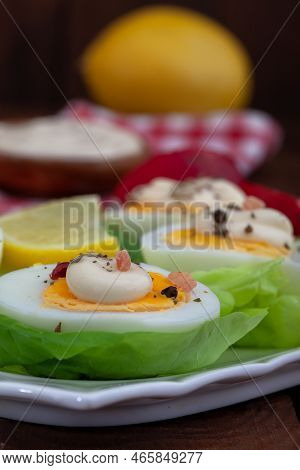 Appetizer Of Boiled Eggs With Mayonnaise And Spices. Eggs With Mayonnaise On Green Lettuce Leaf. Ver