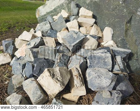 Traditional Portuguese Pavement. Pile Of Cobblestones Over Green