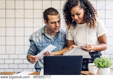 Happy Couple Use Laptop Computer Reading Documents And Calculating Bills To Pay Together.business Co