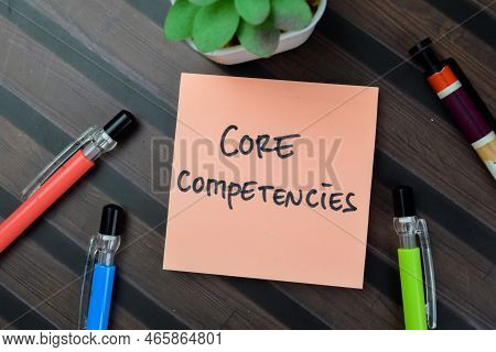 Concept Of Core Competencies Write On Sticky Notes Isolated On Wooden Table.