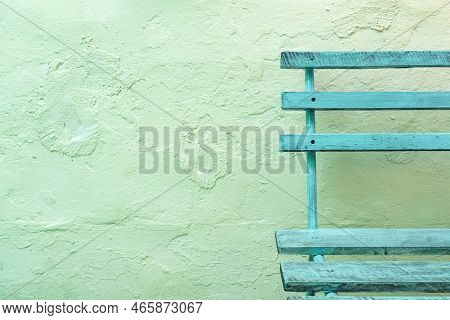 Old Wooden Bench On Timeworn Wall Surface As Copy Space And Background