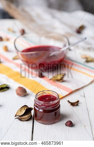 Raspberry Jam On The Table. A Jar With Red Marmalade On A Light-colored Fabric. Rustic Decor Made Fr