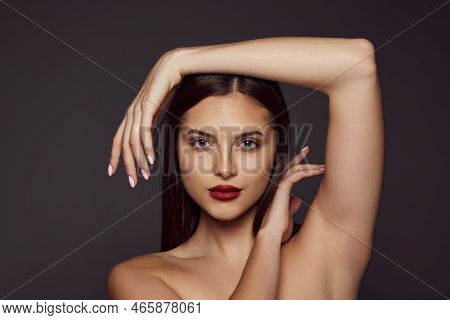 Portrait Of Young Beautiful Girl With Red Lips Posing Isolated Over Dark Grey Background. Facebuildi