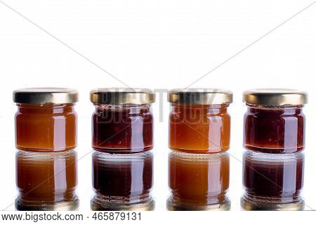 Jam In Many Jars On A White Isolated Background With Reflection. Orange Jelly Apricot Apple. Concept