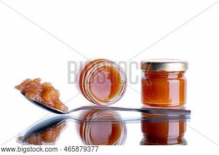Jam In A Jar And A Spoon. Apple And Pear Jam In A Spoon On A White Mirror Background. Healthy Natura