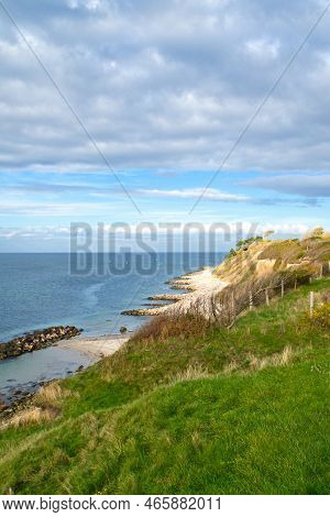 Hundested, Denmark On The Cliff Overlooking The Sea. Baltic Sea Coast, Grassy Meadow, Beach. Clouds 