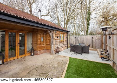 Toft, Cambridgeshire, England - March 4 2019: Enclosed Patio Style Landscaped House Garden With Furn