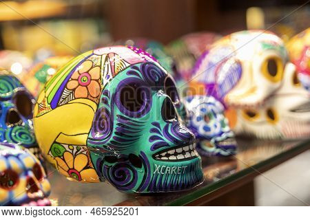 Xcaret, Mexico - November 22, 2022: Colorfully Painted Clay Skulls On A Shelf. A Clay Skull Is A Fig
