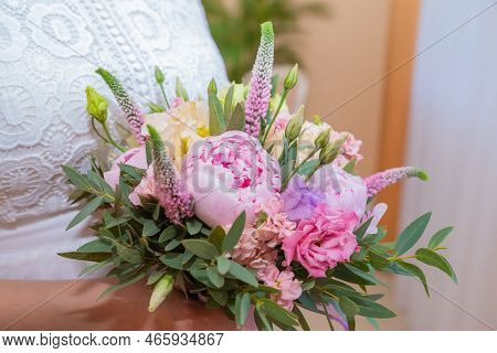 Bridal Bouquet Beautiful Of Pink Wedding Flowers In Hands Of The Bride. Close-up Interior Studio Sho